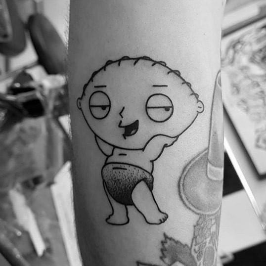 Tattoo of Stewie Griffin from Family Guy in black ink, striking a sassy pose with hands behind his head, wearing only underwear with a confident expression.