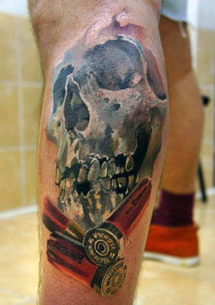 Realistic skull tattoo with shotgun shells on the leg, featuring bold shading and intricate details for a striking and intense design.