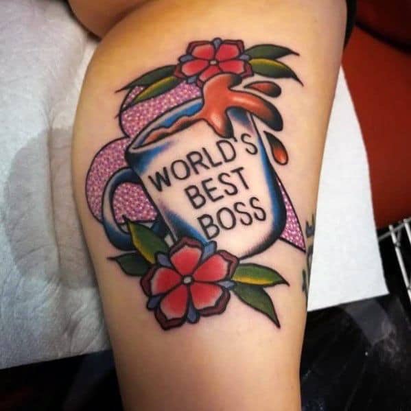 Color tattoo of Michael Scott’s "World’s Best Boss" mug from *The Office*, surrounded by flowers with coffee spilling out.
