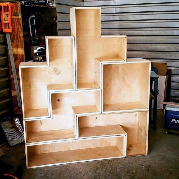 Wooden bookshelf shaped like Tetris blocks in a workshop setting