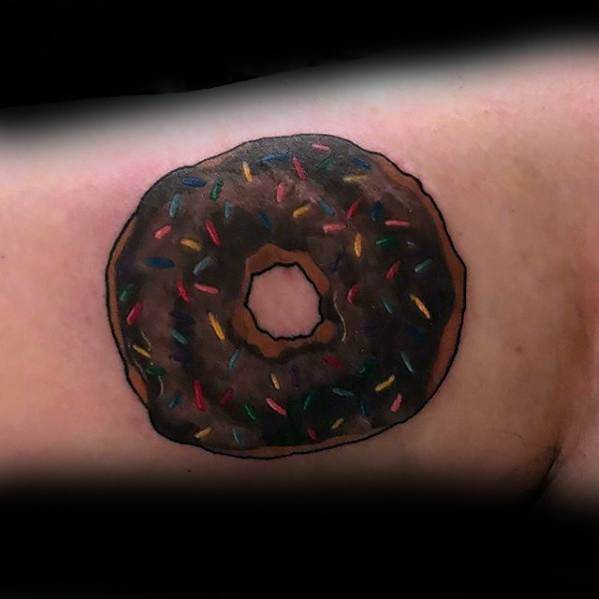 Tattoo of a chocolate frosted donut with colorful sprinkles, shaded for a semi-realistic look with bold outlines and rich tones.