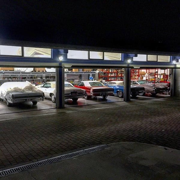 A dream garage showcasing an impressive collection of vintage muscle cars under soft lighting, creating a classic atmosphere.