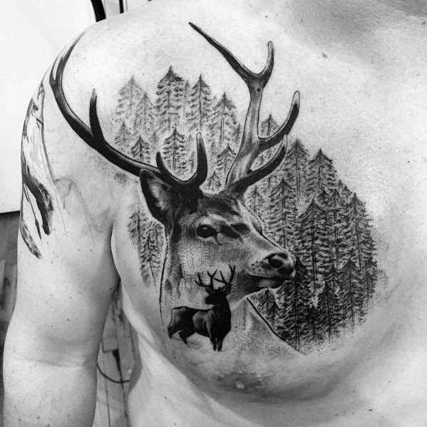 Realistic black and grey elk tattoo on the chest, featuring detailed antlers, a forest background, and a smaller elk silhouette for a bold design.