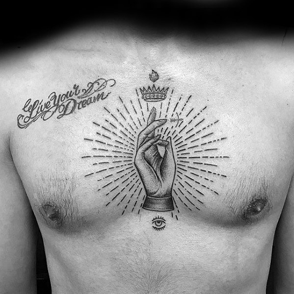 Tattoo of a radiant hand gesture on the chest, crowned above with a drop and eye below, surrounded by the phrase "Live Your Dream."