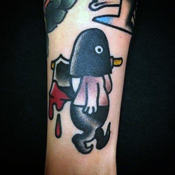 Cartoon-style executioner tattoo featuring a small hooded figure with a single eye, carrying a bloodied axe, in bold black and red ink.