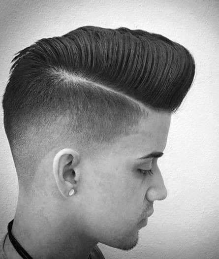 Sleek, voluminous pompadour with a hard part and a high skin fade on the sides and back