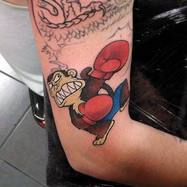 Tattoo of the Evil Monkey from Family Guy wearing red boxing gloves, in an aggressive stance with a fierce expression, ready to throw a punch.