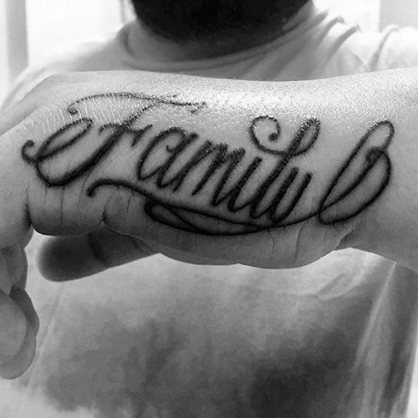 Family" tattoo in cursive on the back of a person's hand