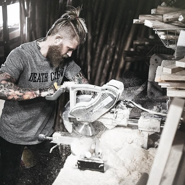 Man with Medium Size Beard and Undercut working in a Wood Shop