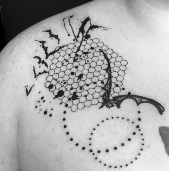 Abstract Hunter S. Thompson-inspired tattoo featuring a hexagonal pattern, bats, and geometric elements in a bold black ink design on the shoulder.