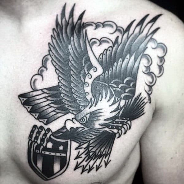 Black and gray tattoo of an eagle holding a shield on a person's chest