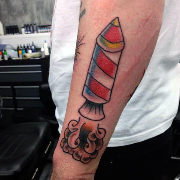 Tattoo of a red and white striped rocket firework launching with smoke and sparks, designed in a bold traditional style with vibrant colors.