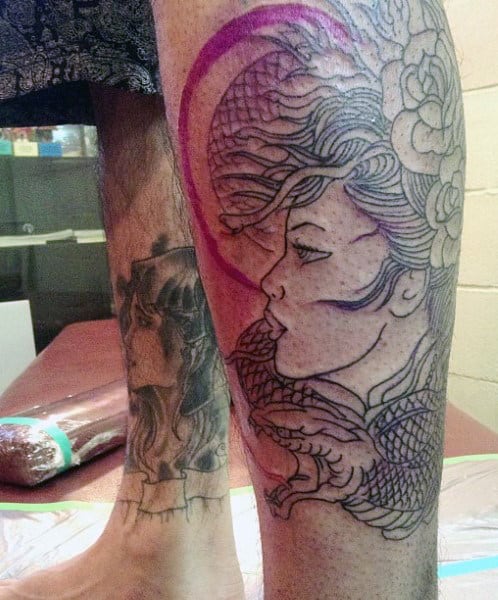 Tattoo design of a woman's face with a snake on a leg