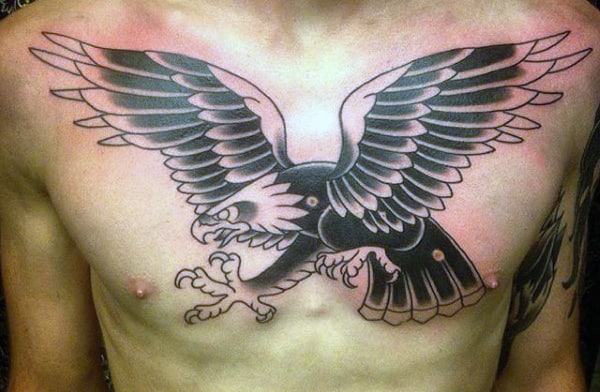 Chest tattoo of a large black and gray eagle with outstretched wings and sharp talons
