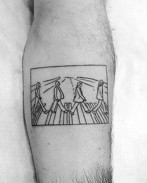 Minimalist linework tattoo of The Beatles' Abbey Road crossing scene, framed like a snapshot with simple outlined figures and street details.