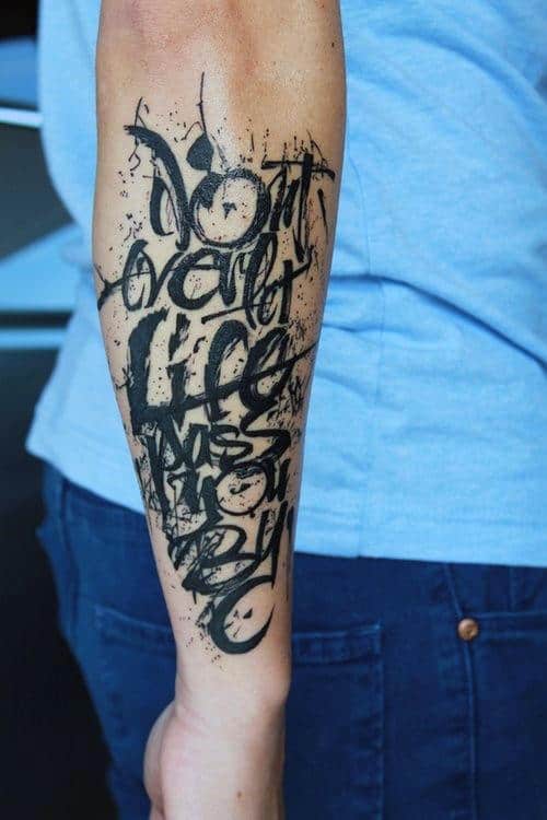 Forearm tattoo with abstract text design
