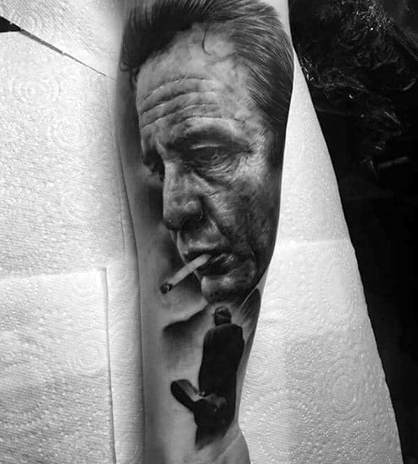 Realistic tattoo of Johnny Cash smoking, with another figure walking below