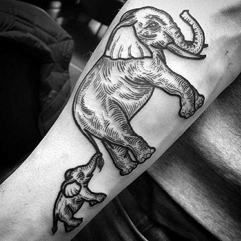Tattoo of a large elephant holding the trunk of a smaller elephant on a forearm