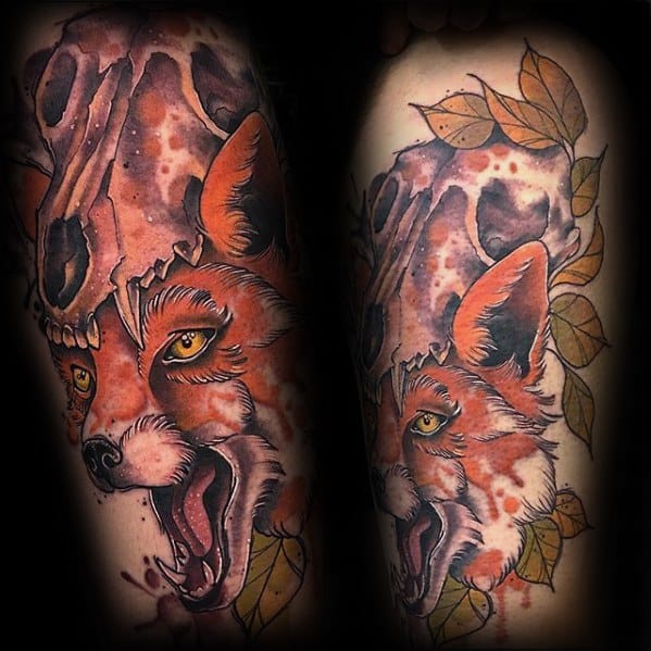 Vibrant tattoo of a fierce fox with a skull above its head and autumn leaves around, done in bold watercolor-style shading.