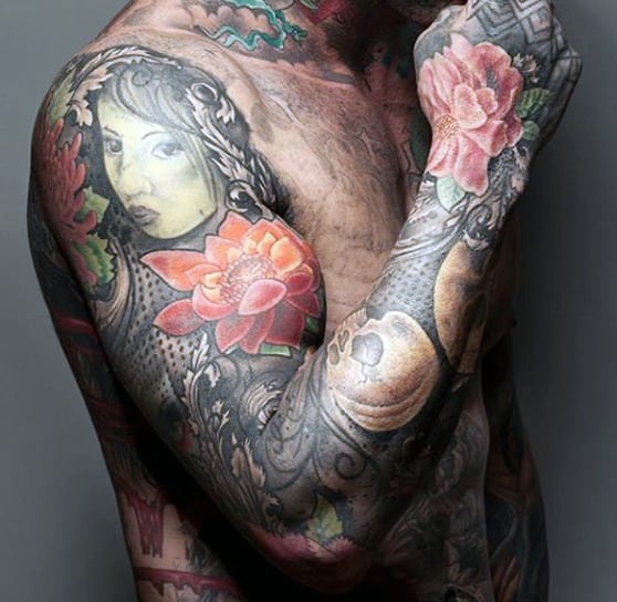 Colorful tattoo including a woman's face and flowers on arm and chest