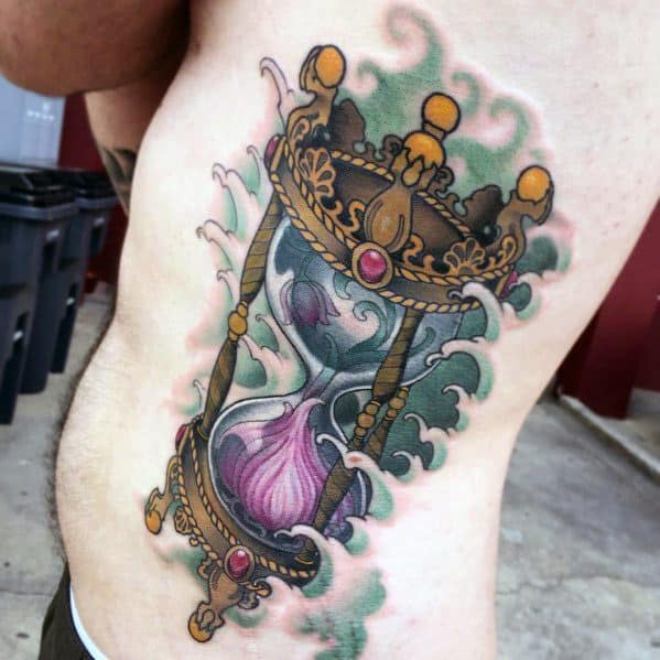 Ornate hourglass tattoo with a garlic bulb inside, featuring rich colors, intricate gold detailing, and swirling smoke for a dramatic and unique design.