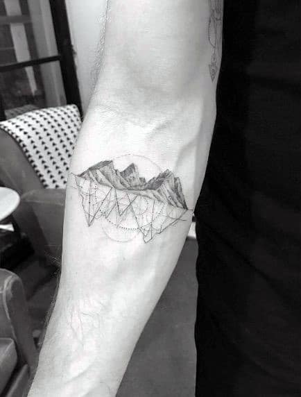 Fine line forearm tattoo of mountains with overlapping geometric triangles and dotted circles for a detailed, modern design.