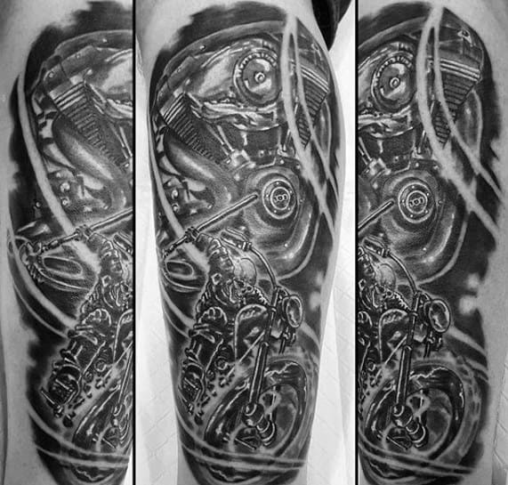 Black and grey Ghost Rider tattoo showcasing a detailed motorcycle engine and rider emerging from swirling smoke in a dynamic sleeve design.