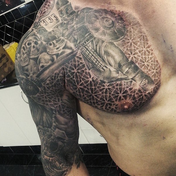 A gladiator lifting weights tattooed on a male torso and arm with intricate designs