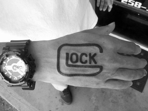 Black ink tattoo of the Glock logo on the top of the hand, featuring a bold and simple design for a striking and unmistakable statement.