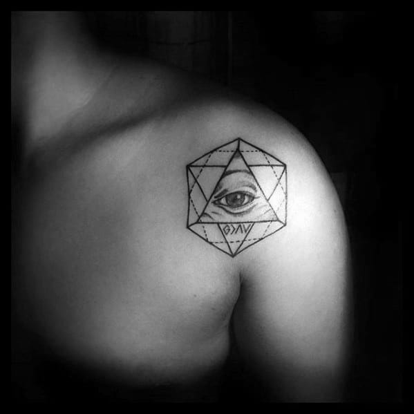 Shoulder tattoo featuring "God is greater than the highs and lows" symbol within geometric shapes and an eye design