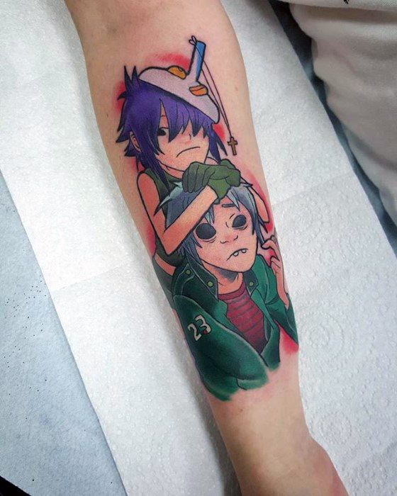 Vibrant forearm tattoo of Noodle placing a hat on 2D’s head, featuring rich colors, playful expressions, and a soft red background glow.