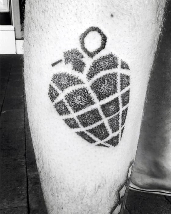 Dotwork tattoo of Green Day’s iconic heart-shaped grenade design, rendered in black ink on the leg with a textured stippling effect.