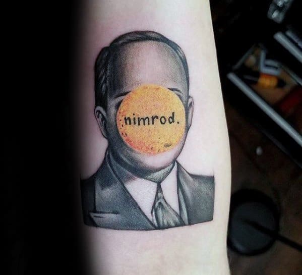 Tattoo of a faceless man in a suit with a yellow “nimrod.” circle over the face, paying tribute to Green Day’s *Nimrod* album.