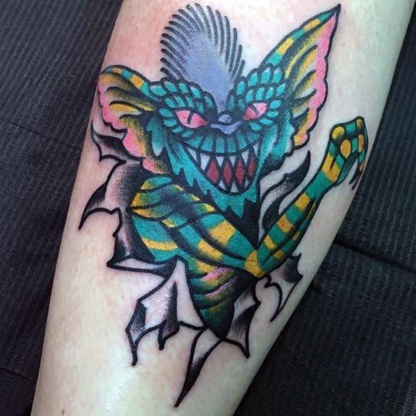 Colorful Gremlin tattoo with bold outlines, bright hues, and a ripped-skin effect, creating a striking and dynamic design.