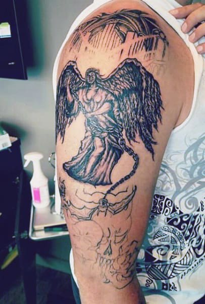 Detailed angel tattoo on a man's upper arm, featuring chains and dark wings