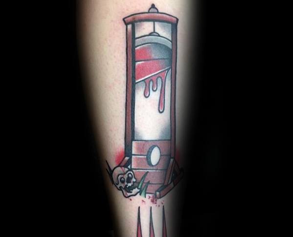 Stylized guillotine tattoo with dripping red blood, bold shading, a cartoonish skull at the base, and splatter effects below the structure.