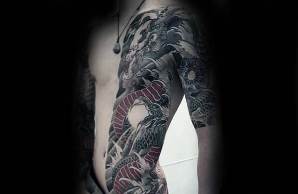 Japanese half-body tattoo featuring a striking dragon design with red and black details, extending along the ribcage and arm