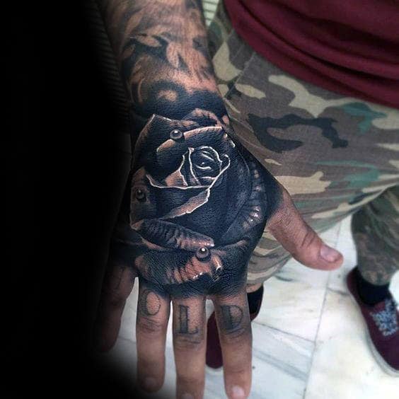 A hand tattooed with a black rose design
