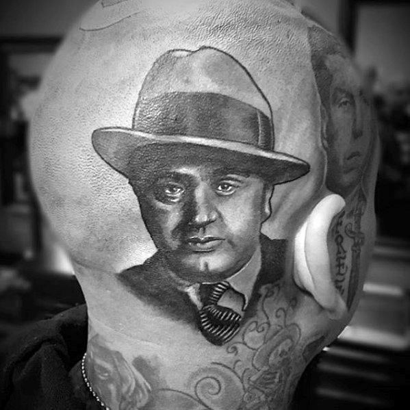 Al Capone tattoo on the back of the head, featuring a black-and-white portrait of the gangster wearing his signature fedora and tie.