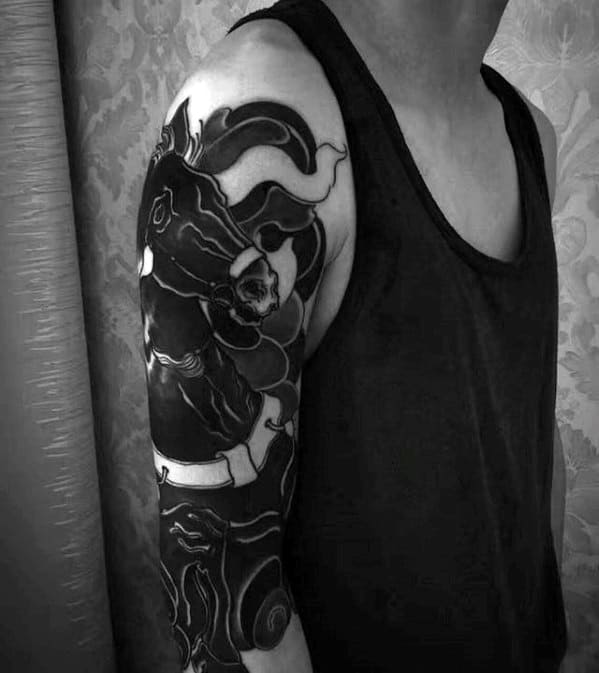 Bold blackwork tattoo of a stylized horse and rider with swirling abstract shapes, covering the upper arm and shoulder