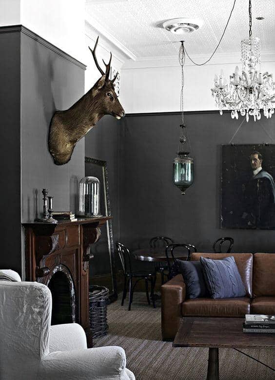 contemporary gray living room brown leather couch mounted deer head ornate fireplace glass chandelier