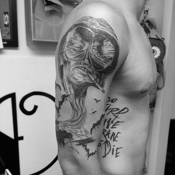 Black and white Hunter S. Thompson tattoo featuring a surreal melting face with aviator glasses, bats, and the quote "Too Weird to Live, Too Rare to Die."
