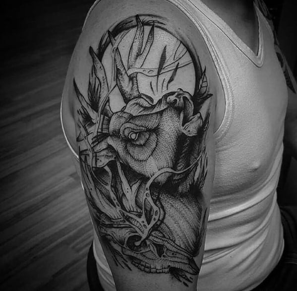 Black and grey elk tattoo on the upper arm, featuring bold linework, intricate shading, and a surreal artistic design for a striking look.