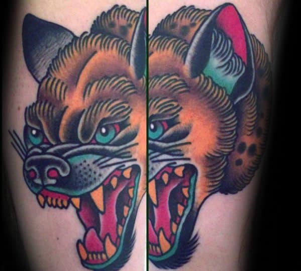 Traditional-style hyena tattoo with bold black outlines, vivid orange fur, teal highlights, and a fierce open-mouth snarl split across two panels.