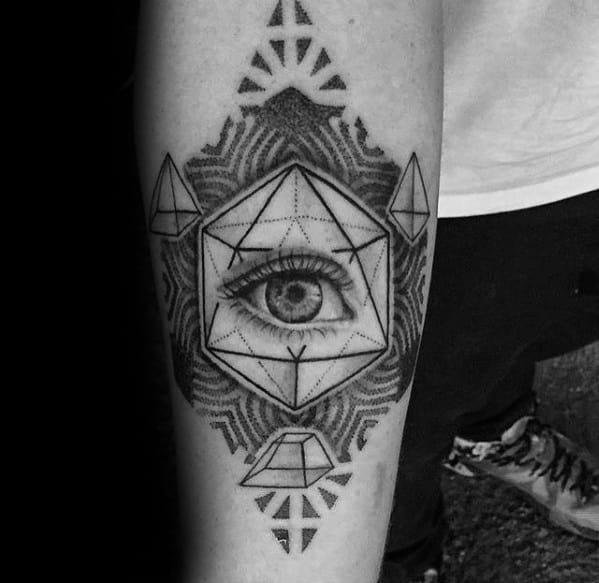 Forearm tattoo featuring an eye within an icosahedron, surrounded by symmetrical geometric patterns and sacred symbolism.