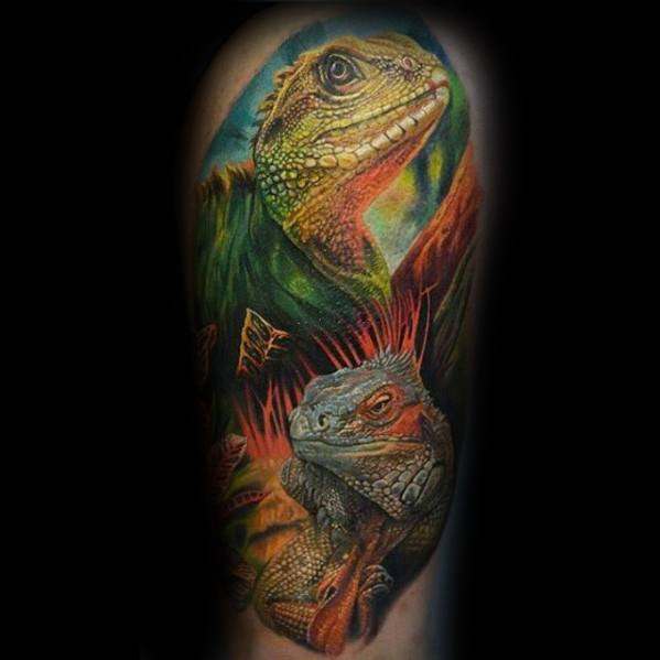 Colorful iguana tattoo featuring two reptiles in vibrant green, orange, and yellow tones with a dynamic jungle-themed background.