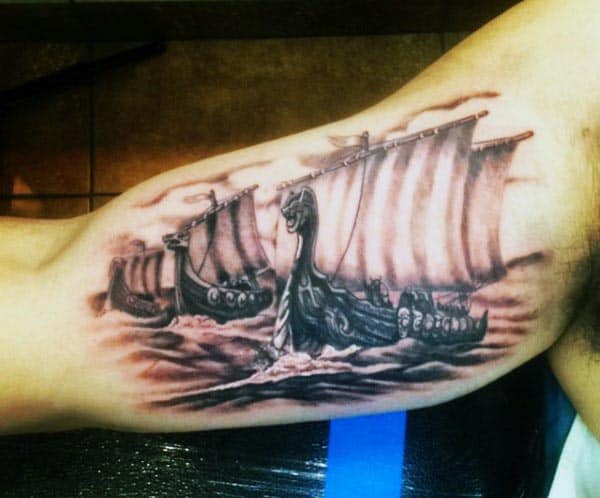 Black and grey tattoo of Viking longships sailing through rough waters, featuring intricate dragon-headed prows and billowing sails