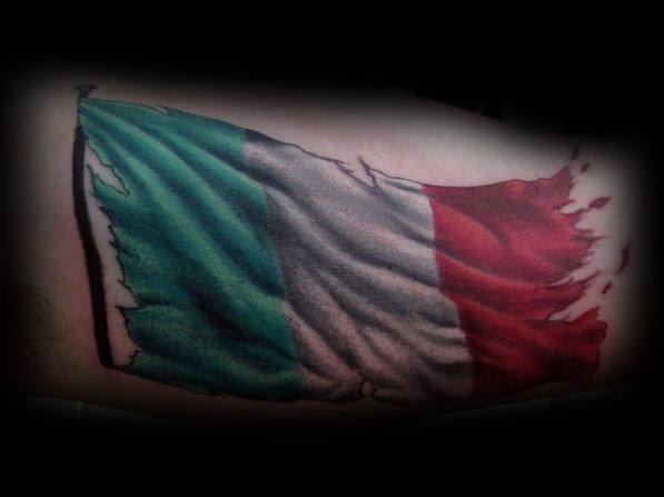 Tattoo of a tattered Italian flag waving, symbolizing resilience, national pride, and a strong connection to Italian heritage.