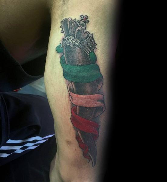 Black Italian horn tattoo with a crowned design and tricolor ribbon, symbolizing strength, heritage, and protection.