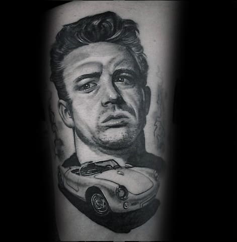 Black and grey tattoo of James Dean with a serious expression, featuring his iconic Porsche 550 Spyder below his portrait.